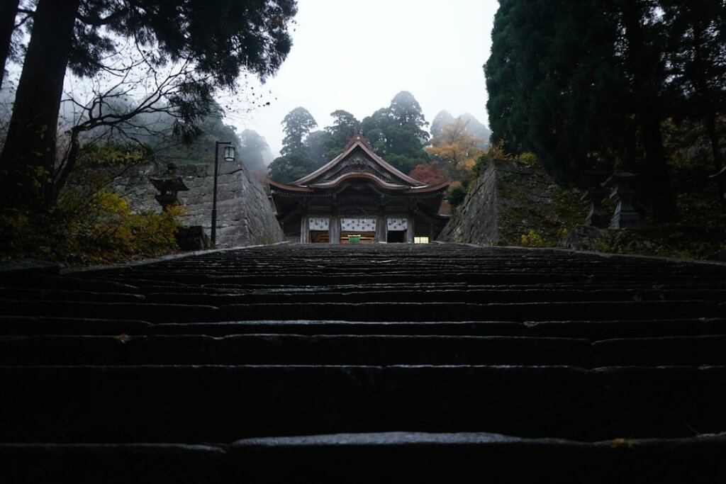 Misty mountain temple landscape, illustrative Demon Slayer viewing guide